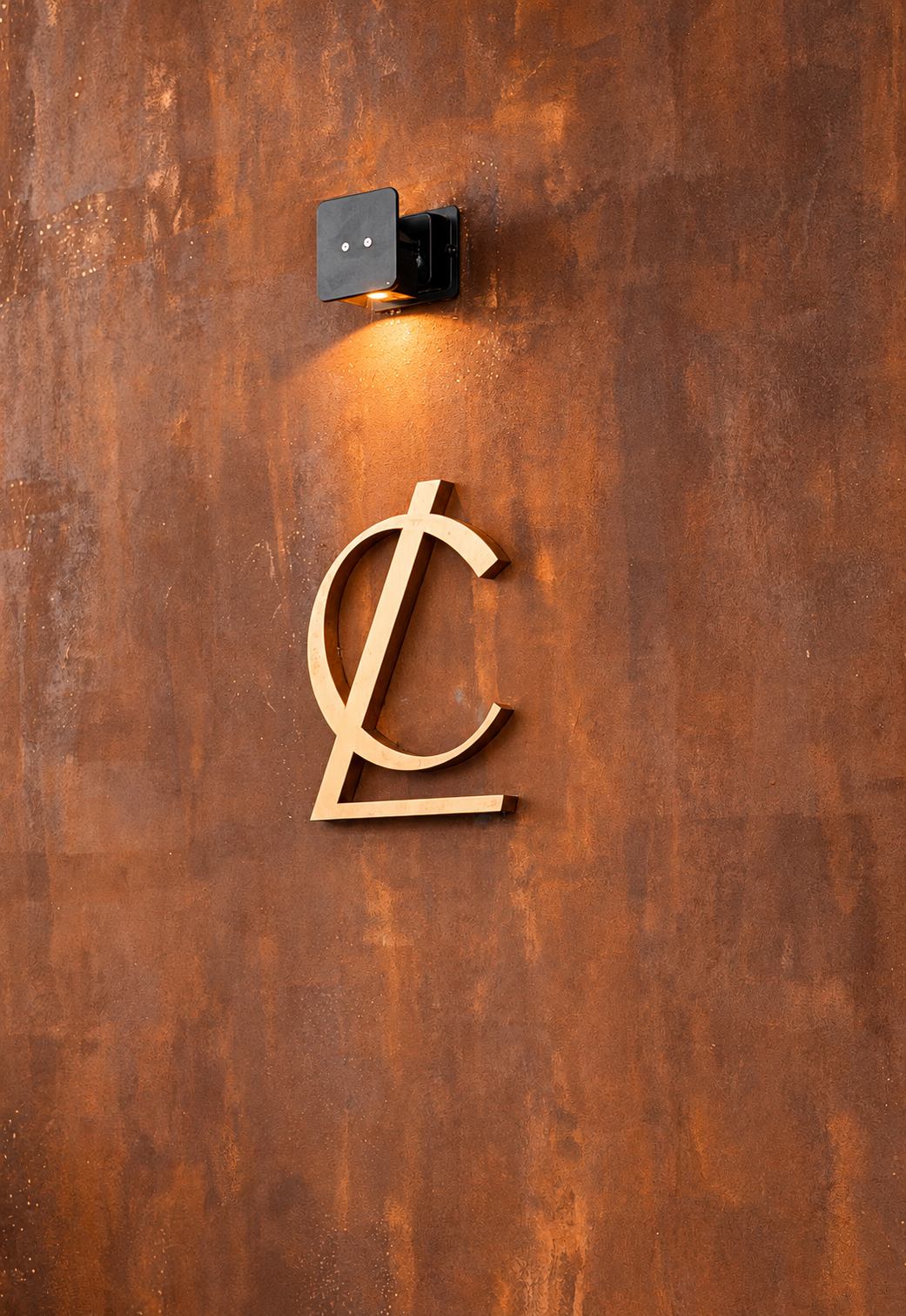 Rustic paint finish behind a brass monogram sign